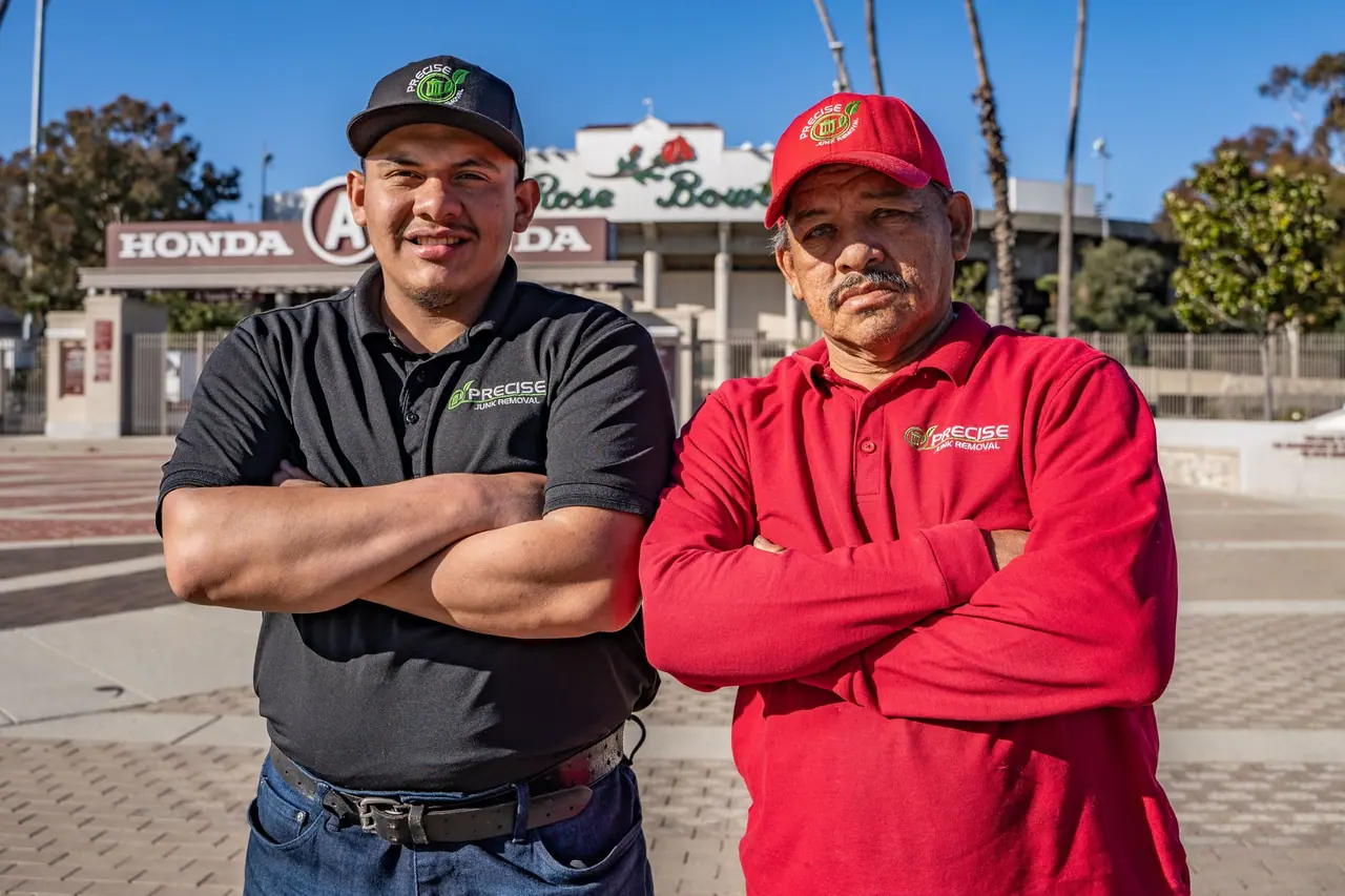 Angel and a crew member standing with their arms folded outside the Rose Bowl