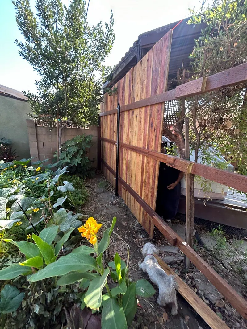 An old wooden fence leaning off its posts with a broken section, ready to come out