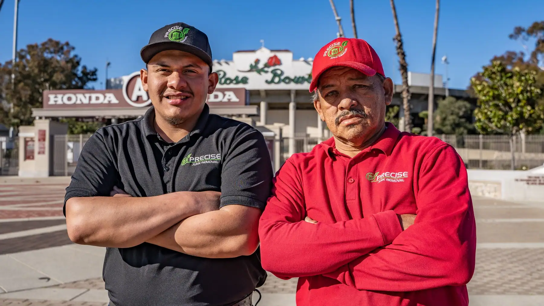 The father and son behind Precise Junk Removal, arms folded in branded shirts outside the Rose Bowl in Pasadena