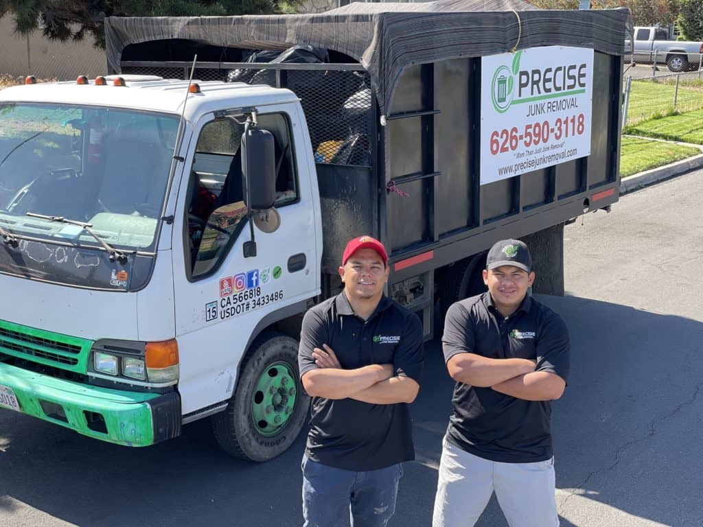 Precise Junk Removal experts posing with a junk truck